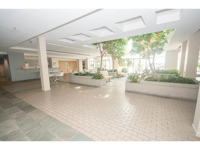 Furnished living room with modern decor, large windows, and a view of greenery. - 1213 - 989 Nelson, Vancouver Downtown