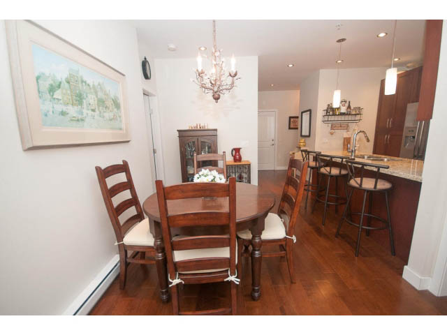 Furnished dining area with wooden chairs and hardwood floors. - 205 - 116 West 23rd, North Vancouver