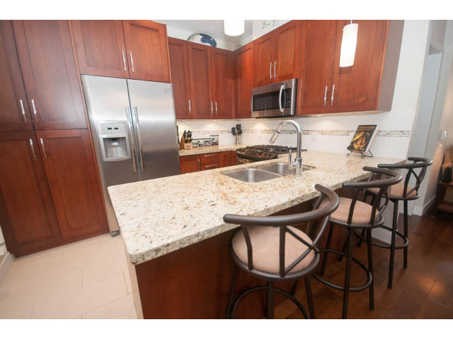 Bright kitchen with granite countertops, hardwood floors, and a city view. - 205 - 116 West 23rd, North Vancouver