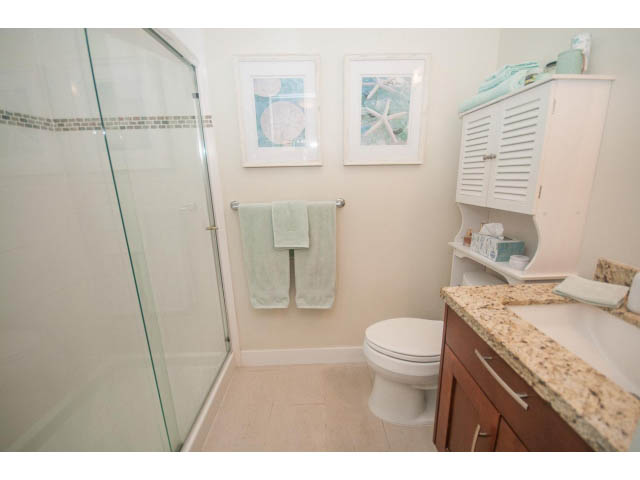 Furnished bathroom with granite countertop and wooden cabinet. - 205 - 116 West 23rd, North Vancouver