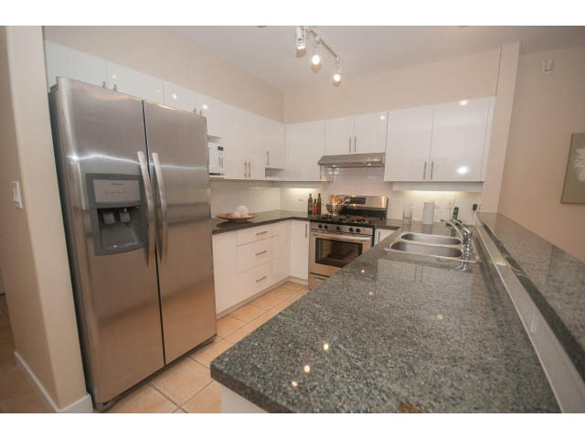 Bright kitchen with granite countertops and stainless steel appliances. - 202 - 3629 Deercrest, North Vancouver