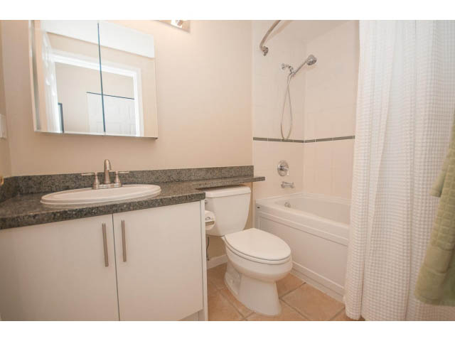 Furnished bathroom with granite countertop and white cabinetry. - 202 - 3629 Deercrest, North Vancouver