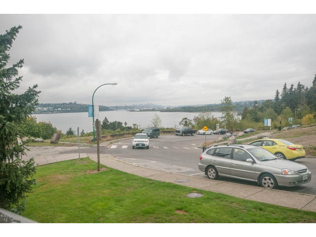 Bright living room with city view and greenery, furnished with modern decor. - 202 - 3629 Deercrest, North Vancouver