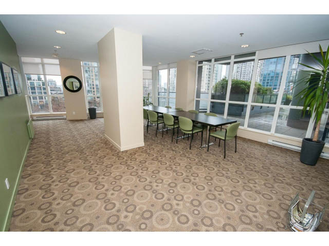 Furnished living room with large windows, city view, and patterned carpet. - 2102 - 1199 Seymour Street, Vancouver Downtown