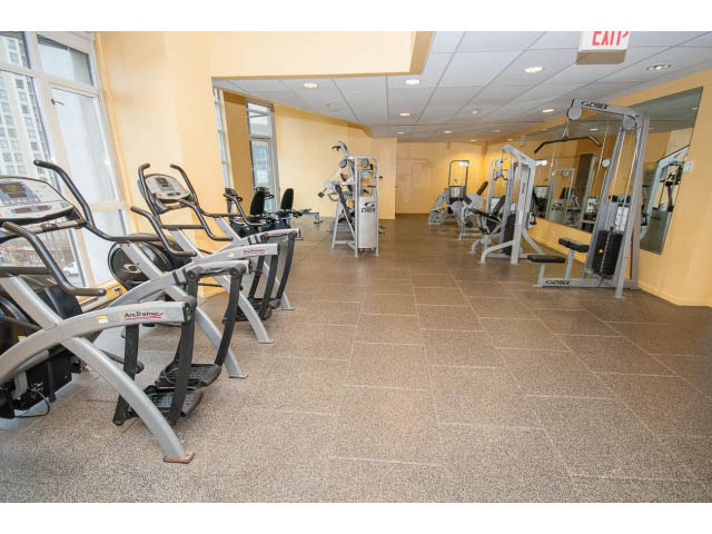 Bright gym with cardio machines and mirrors, clean tile flooring. - 2102 - 1199 Seymour Street, Vancouver Downtown