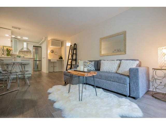 Furnished living room with hardwood floors, modern furniture, and a cozy ambiance. - 306 - 570 E 8th Avenue, Vancouver East Side