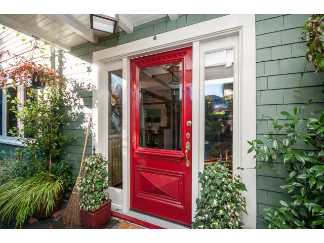 Bright entrance with red door and green siding, surrounded by plants. - 1015 West 16th Ave, Vancouver West Side