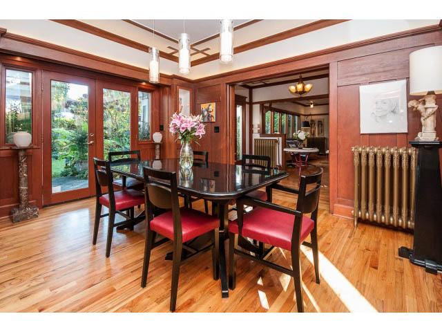 Furnished dining room with hardwood floors and large windows, showcasing natural light and greenery. - 1015 West 16th Ave, Vancouver West Side