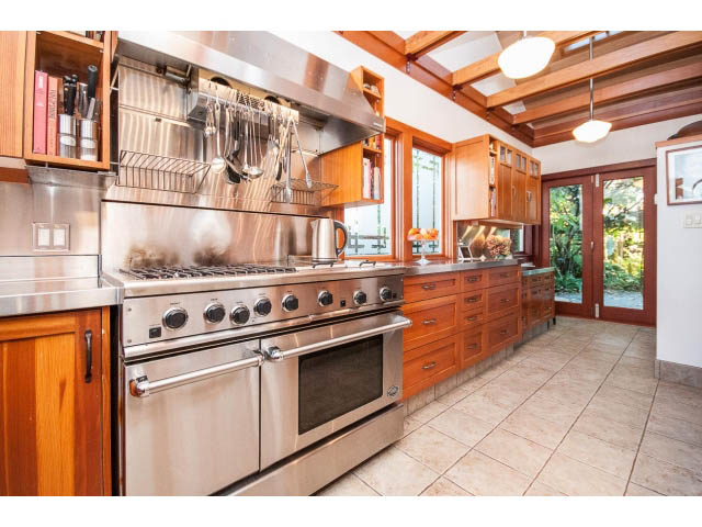 Bright kitchen with stainless steel appliances, wood cabinets, and large windows. - 1015 West 16th Ave, Vancouver West Side