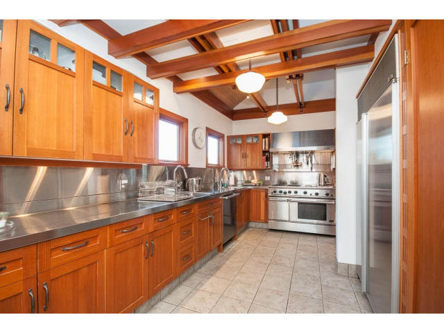 Bright kitchen with wooden cabinets, stainless steel appliances, and tiled flooring. - 1015 West 16th Ave, Vancouver West Side