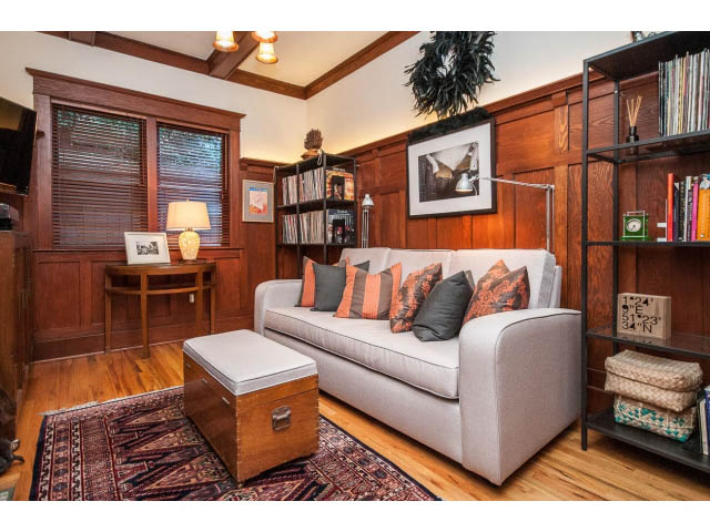 Furnished living room with hardwood floors, cozy couch, and wooden bookshelves. - 1015 West 16th Ave, Vancouver West Side