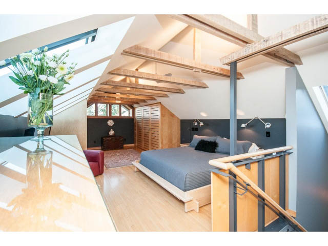 Bright bedroom with wooden beams, hardwood floors, and a modern bed setup. - 1015 West 16th Ave, Vancouver West Side