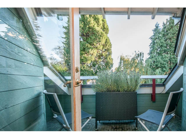 Furnished patio with green walls, outdoor furniture, and a view of trees. - 1015 West 16th Ave, Vancouver West Side