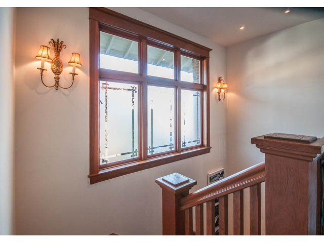 Staircase with wooden railings and sconces, leading to upper floor. - 1015 West 16th Ave, Vancouver West Side