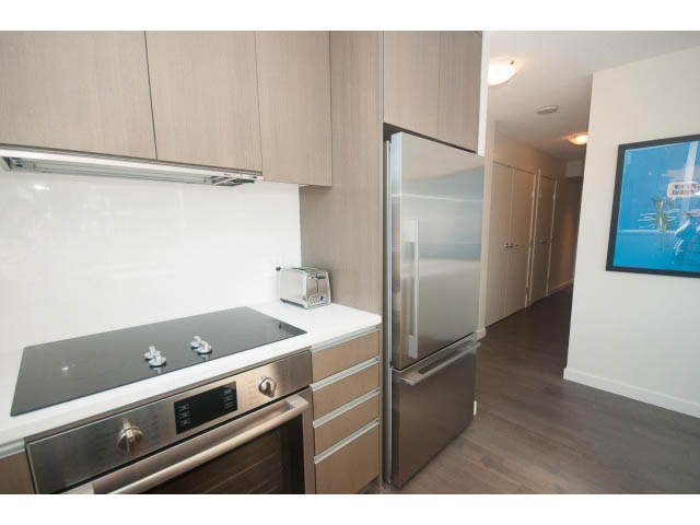 Bright kitchen with stainless steel appliances, white countertops, and hardwood floors. - 805 - 1009 Harwood Street, Vancouver Downtown