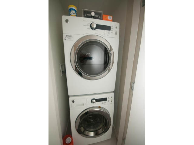 Bright laundry room with stacked washer and dryer, clean and organized. - 805 - 1009 Harwood Street, Vancouver Downtown