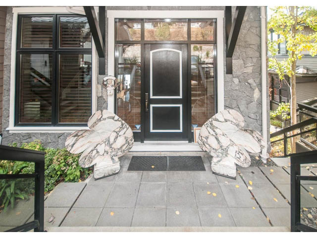 Furnished entryway with stone walls and glass door, leading to a cozy interior. - 3765 Dollarton Hwy, North Vancouver