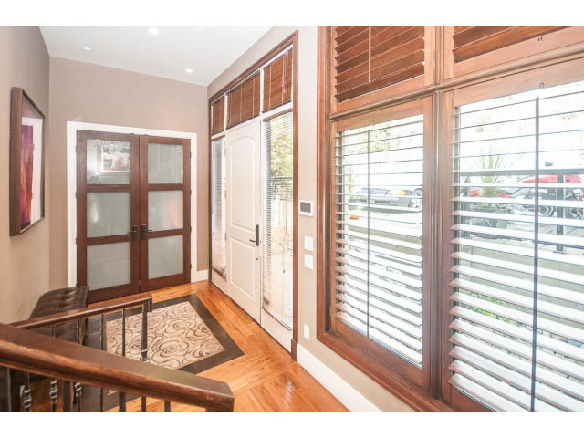 Bright living room with hardwood floors and large windows offering a city view. - 3765 Dollarton Hwy, North Vancouver