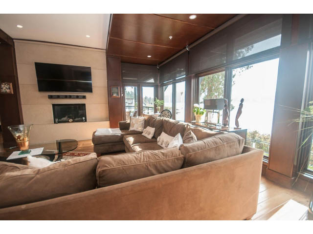 Furnished living room with large windows, hardwood floors, and a city view. - 3765 Dollarton Hwy, North Vancouver
