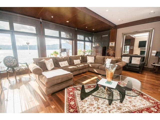 Spacious living room with large windows, hardwood floors, and a view of the water. - 3765 Dollarton Hwy, North Vancouver