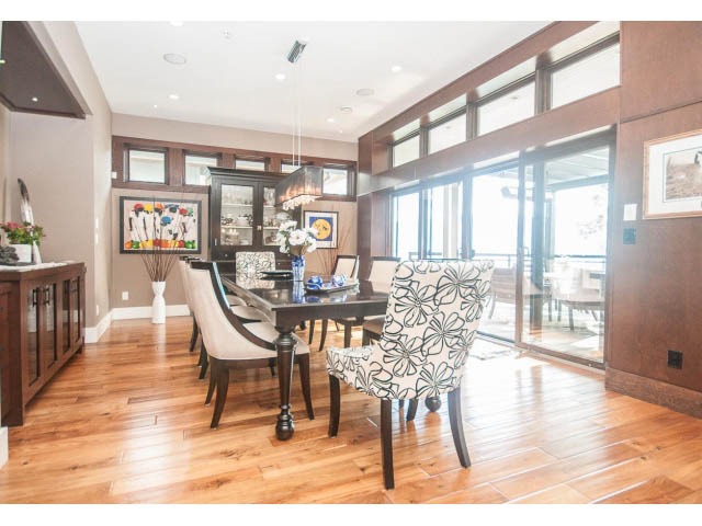Bright dining room with hardwood floors, modern decor, and large windows offering a city view. - 3765 Dollarton Hwy, North Vancouver