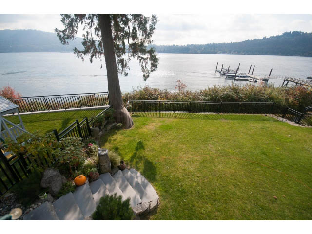 Bright living room with expansive lake view and lush green lawn. - 3765 Dollarton Hwy, North Vancouver