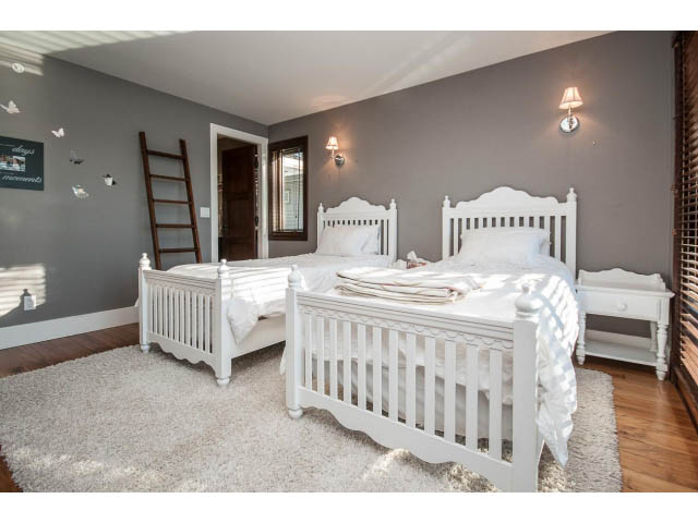 Bright bedroom with white furniture, hardwood floors, and a cozy rug. - 3765 Dollarton Hwy, North Vancouver
