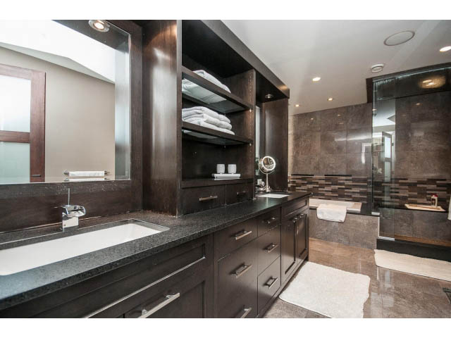 Spacious bathroom with dark wood cabinets, granite countertops, and a walk-in shower. - 3765 Dollarton Hwy, North Vancouver