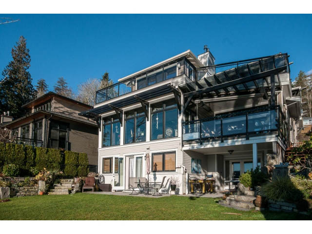 Bright living room with large windows, outdoor seating, and lush greenery. - 3765 Dollarton Hwy, North Vancouver