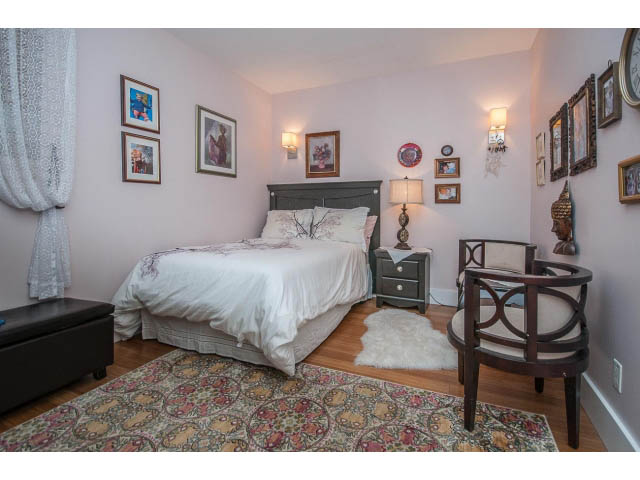 Spacious bedroom with a cozy bed, patterned rug, and wall art. - 3765 Dollarton Hwy, North Vancouver
