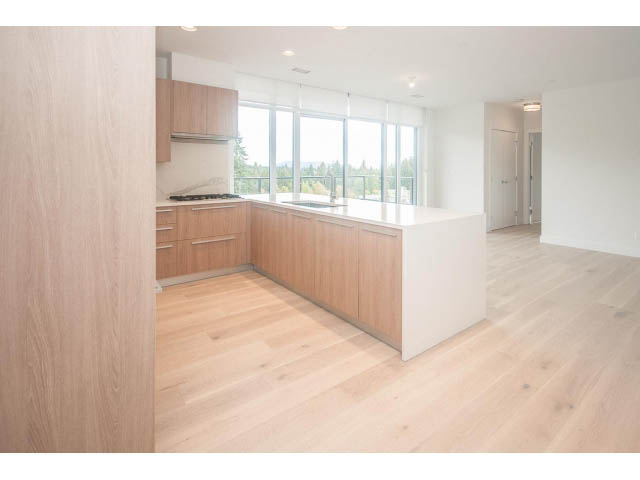 Bright kitchen with light wood cabinets, hardwood floors, and a city view. - 510 - 2738 Library Lane, North Vancouver
