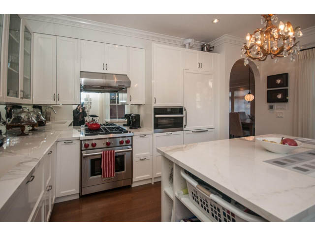 Bright kitchen with white cabinets, marble countertops, and hardwood floors. - 1973 W 15th Ave, Vancouver West Side