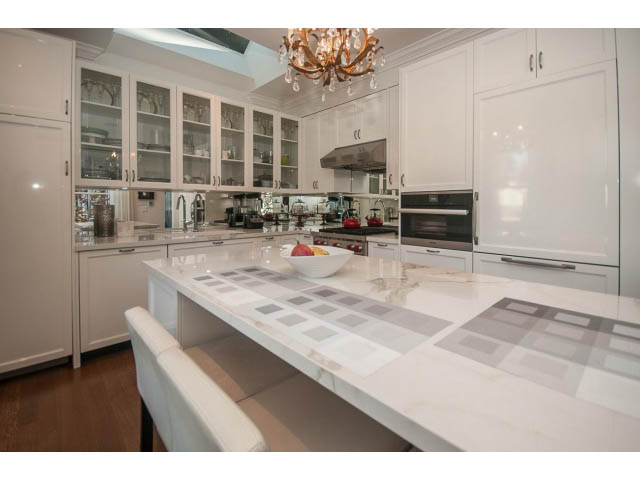 Bright kitchen with white cabinets, marble countertops, and hardwood floors. - 1973 W 15th Ave, Vancouver West Side
