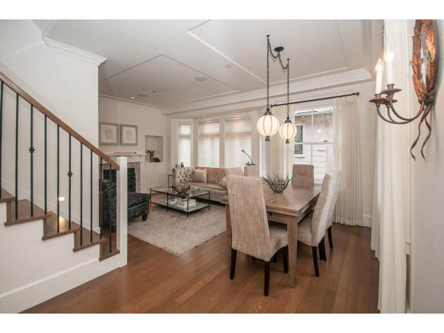 Spacious living room with hardwood floors, large windows, and a cozy fireplace. - 1973 W 15th Ave, Vancouver West Side