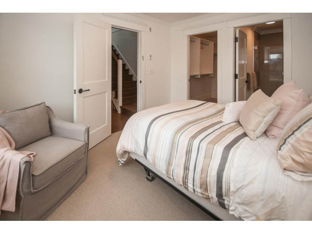 Furnished bedroom with striped bedding and cozy seating area. - 1973 W 15th Ave, Vancouver West Side