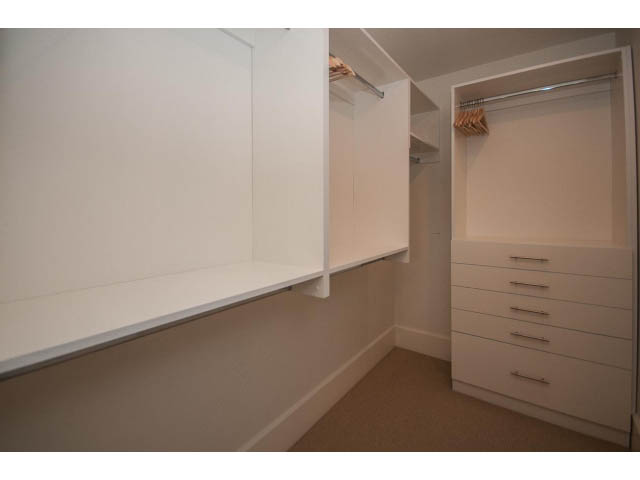 Spacious walk-in closet with built-in shelves and drawers, clean white finish. - 1973 W 15th Ave, Vancouver West Side