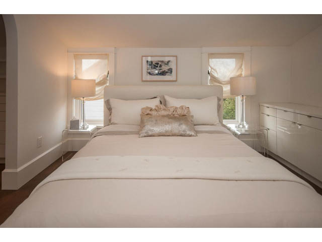 Spacious bedroom with white bedding, large windows, and a modern dresser. - 1973 W 15th Ave, Vancouver West Side