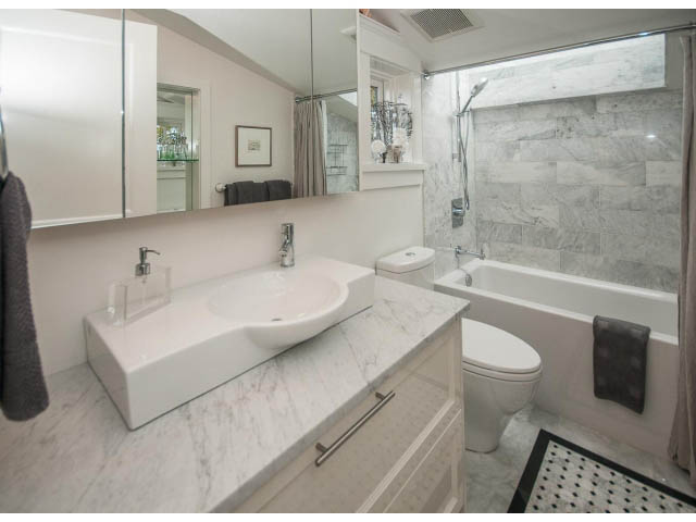 Modern bathroom with marble countertops and a walk-in shower. - 1973 W 15th Ave, Vancouver West Side