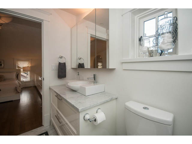 Bright bathroom with marble countertops and a large mirror. - 1973 W 15th Ave, Vancouver West Side