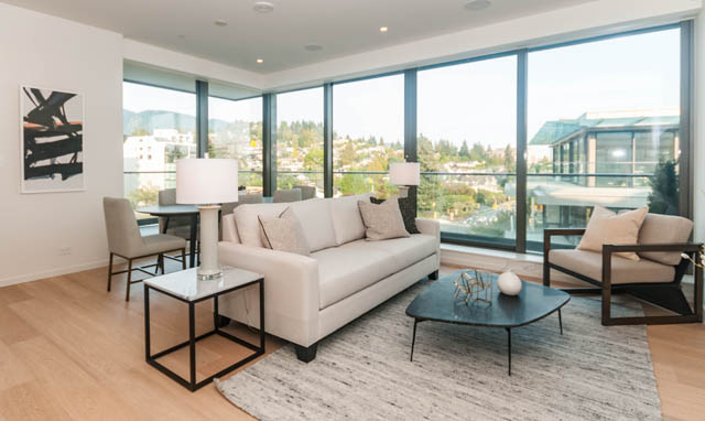Bright living room with hardwood floors, city view, and modern furniture. - 601 - 1355 Bellevue Ave, West Vancouver