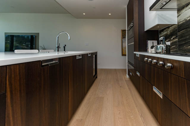 Bright kitchen with modern wood cabinets, white countertops, and a city view. - 601 - 1355 Bellevue Ave, West Vancouver