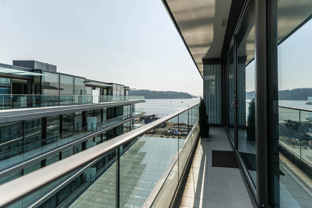 Bright living room with expansive glass windows and a stunning city view. - 601 - 1355 Bellevue Ave, West Vancouver