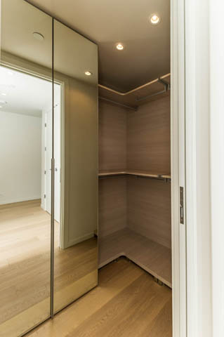 Furnished closet with wooden shelves and mirrored doors. - 601 - 1355 Bellevue Ave, West Vancouver