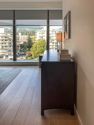Bright living room with hardwood floors and city view. - 601 - 1355 Bellevue Ave, West Vancouver