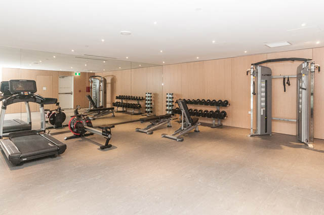 Bright and spacious gym with cardio machines, weights, and mirrors. - 601 - 1355 Bellevue Ave, West Vancouver