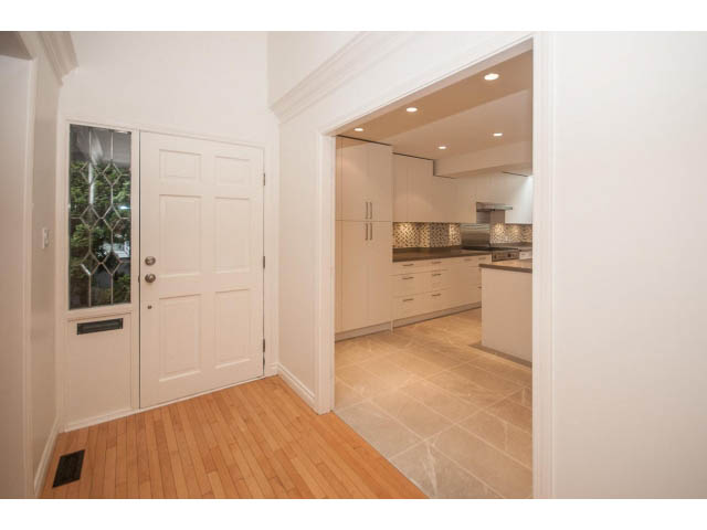 Bright kitchen with white cabinets, hardwood floors, and a city view. - 4428 Marine Drive, West Vancouver