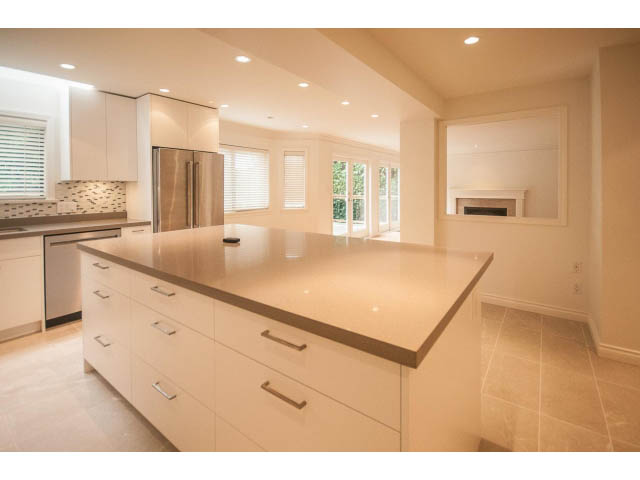 Bright kitchen with white cabinets, granite countertops, and large windows. - 4428 Marine Drive, West Vancouver