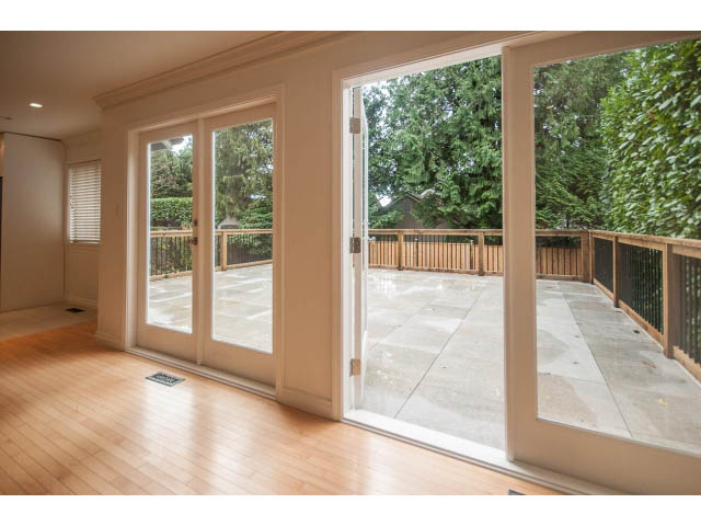 Bright living room with hardwood floors and sliding glass doors leading to a deck. - 4428 Marine Drive, West Vancouver