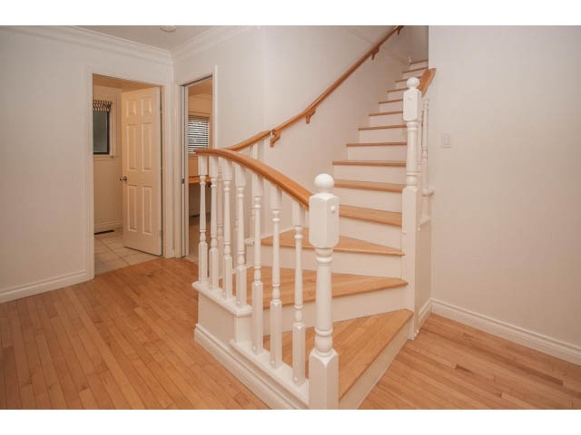 Bright entryway with hardwood floors and white staircase leading to upper level. - 4428 Marine Drive, West Vancouver
