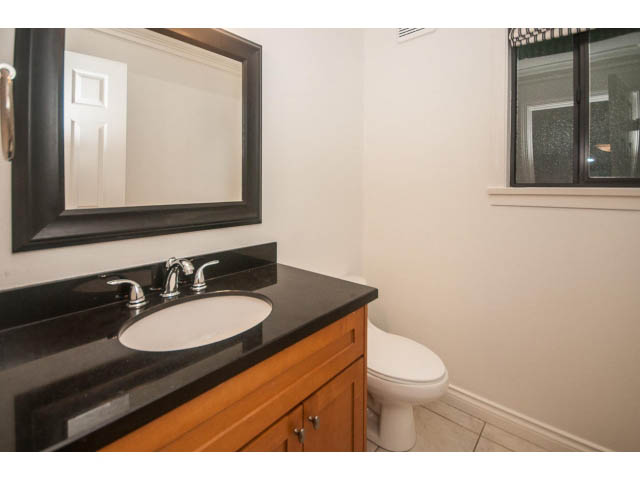Bathroom with black countertop and wooden cabinets. - 4428 Marine Drive, West Vancouver